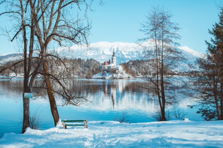 A landscape of Lake Bled with snow on the shores