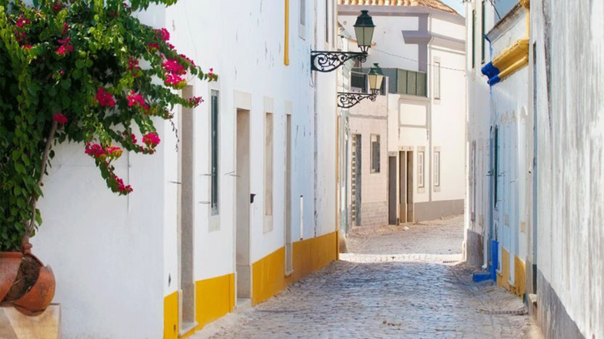 Uma rua tranquila e pintada de branco em Faro, Portugal