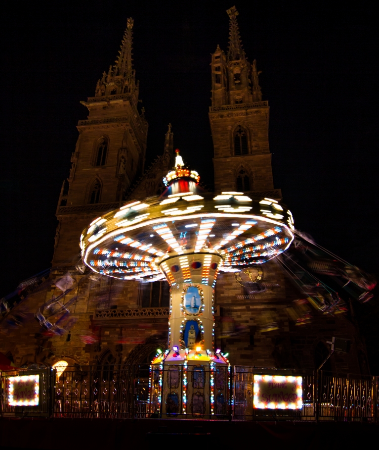 Os brinquedos da feita de Herbstmesse iluminam as ruas de Basileia 