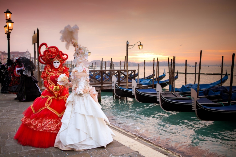 Masked women in Venice at sunset