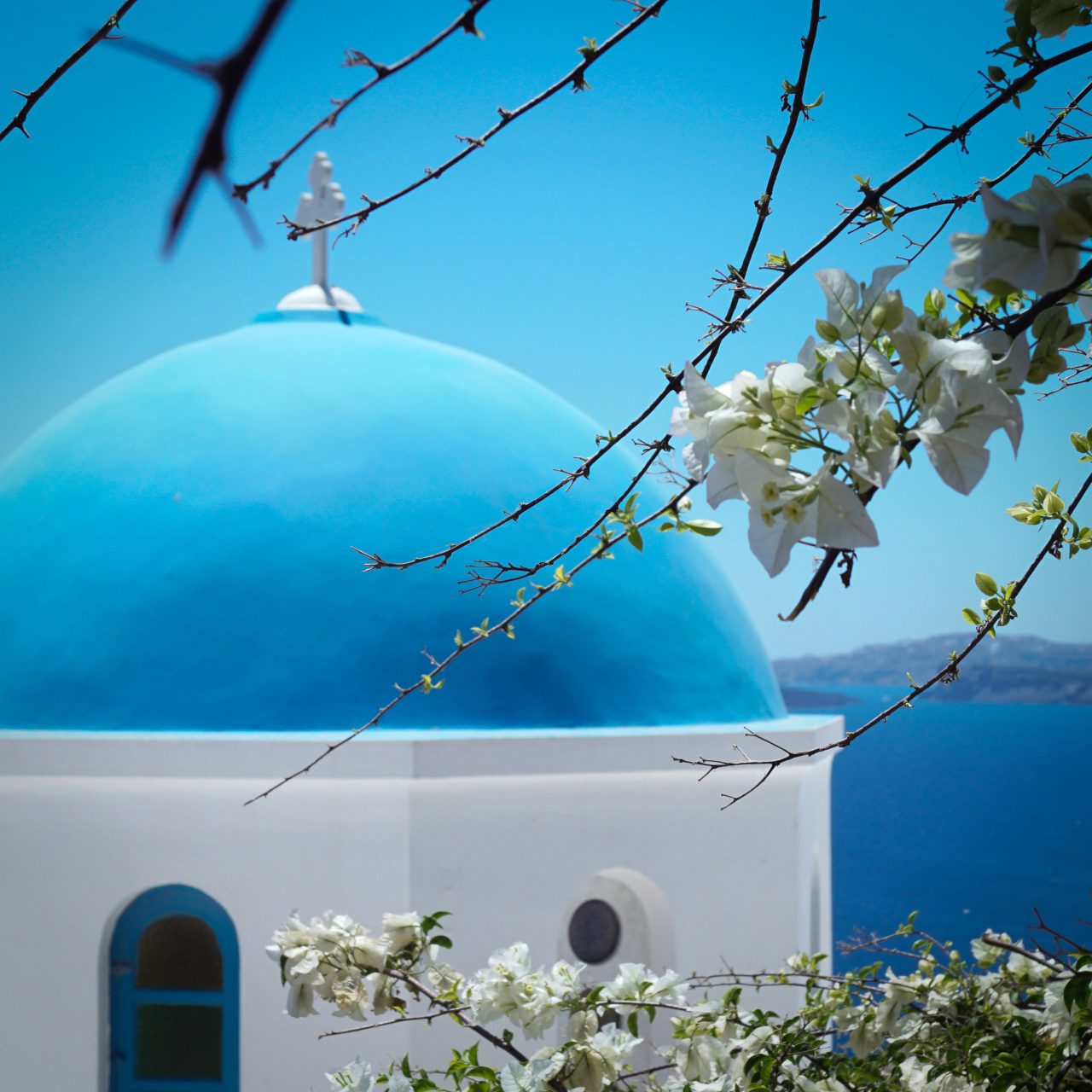 Close-up of a blue-domed church in Santorini